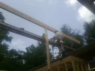 Carpenter setting a ridge beam over a new addition frame — Ice Dam Removal by Roofing Brothers in Ayr