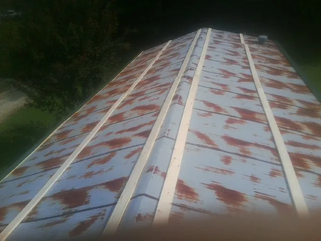 Rusted metal roof panels with new wood purlins before replacement — Storm Damage Roof Repair in Ayr by Roofing Brothers