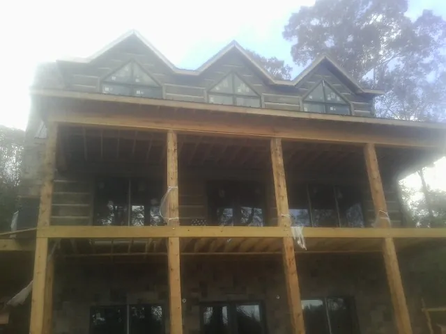 Dormers and porch framing on a large log home under construction — Roof Coating work by our crew in Ayr