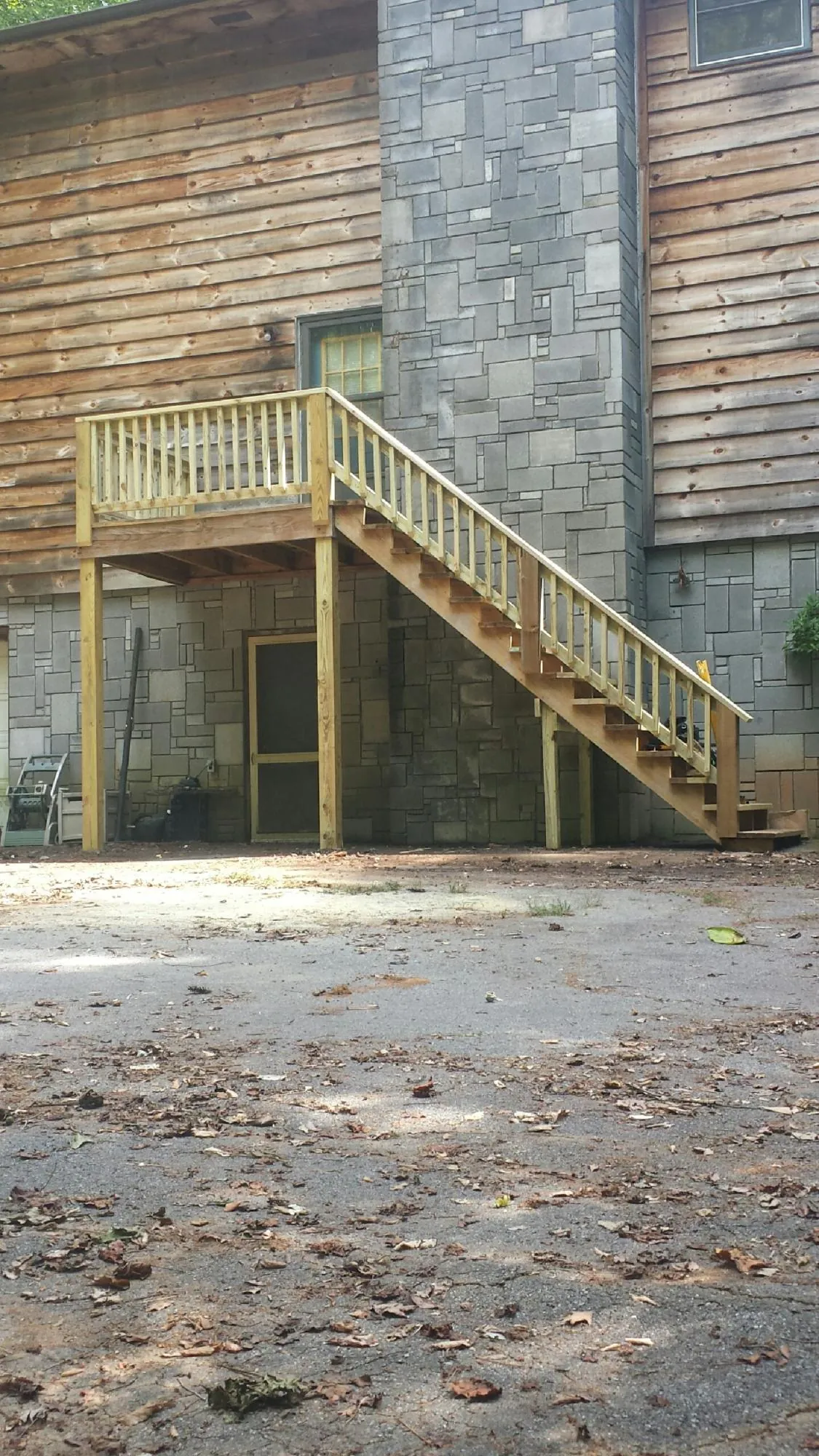 New pressure treated deck and stair landing on a log home in Ayr