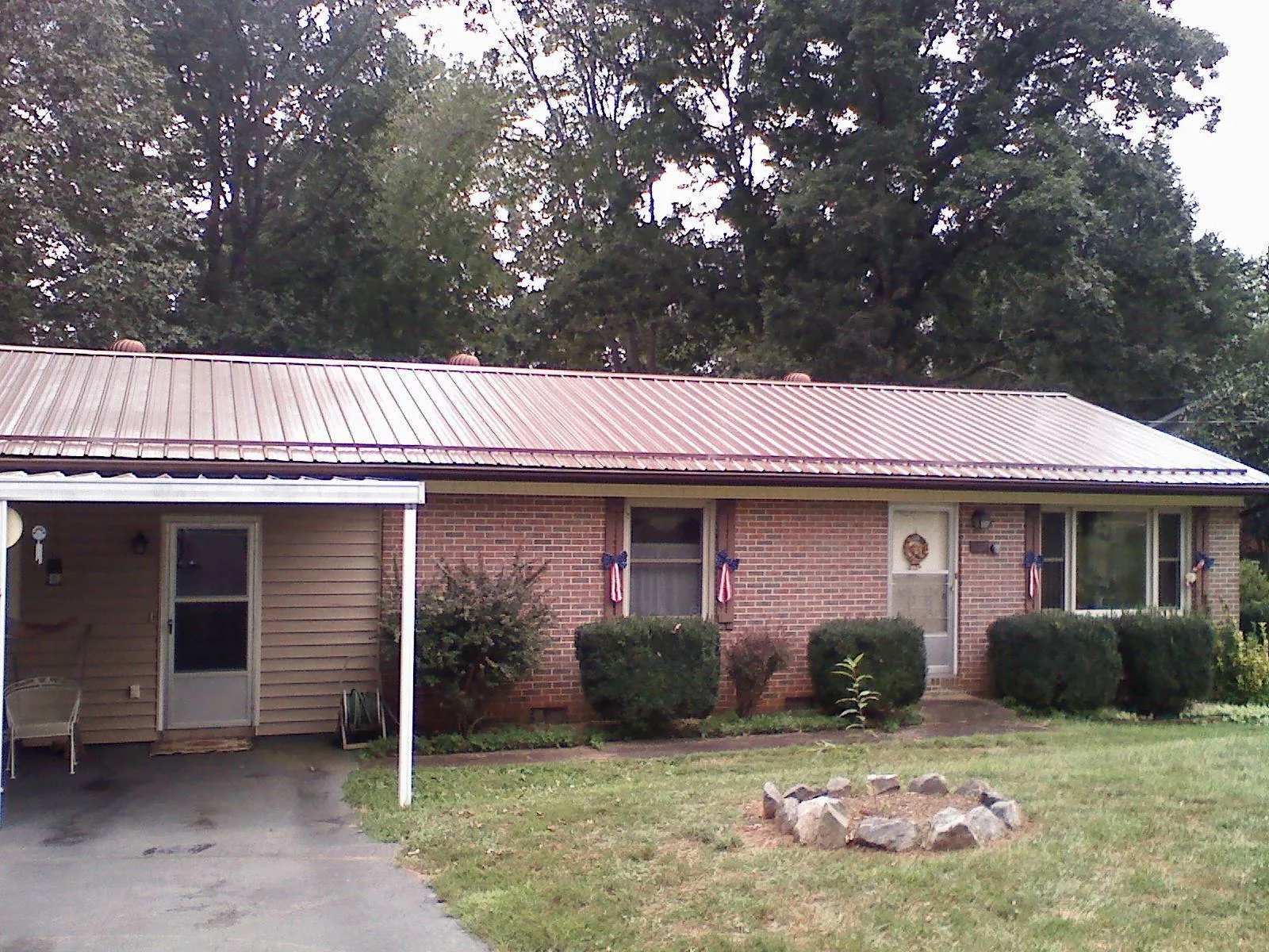 Bronze metal roof and carport on a brick ranch home — Roof Repair work by our crew in Ayr